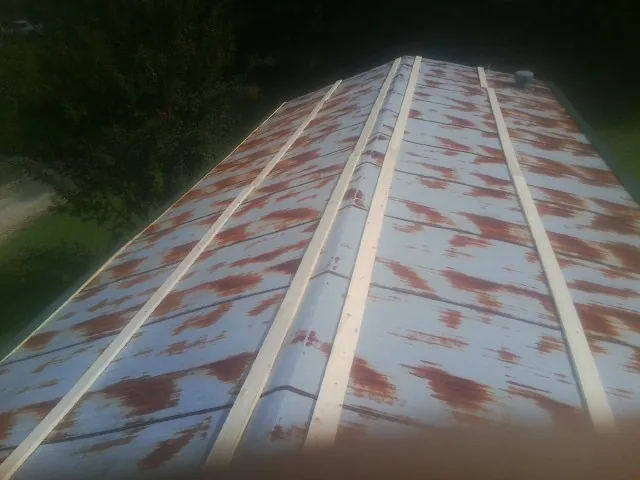 Rusted metal roof panels with new wood purlins before replacement — Storm Damage Roof Repair in Karns City by Roofing Brothers