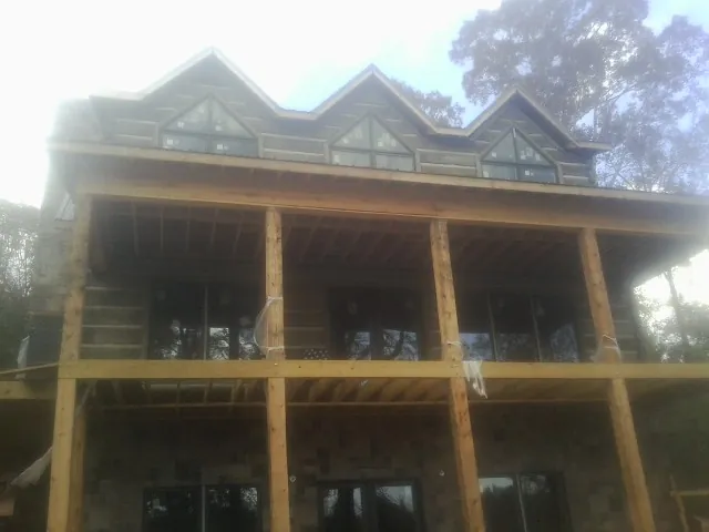 Dormers and porch framing on a large log home under construction — Roof Coating work by our crew in Karns City