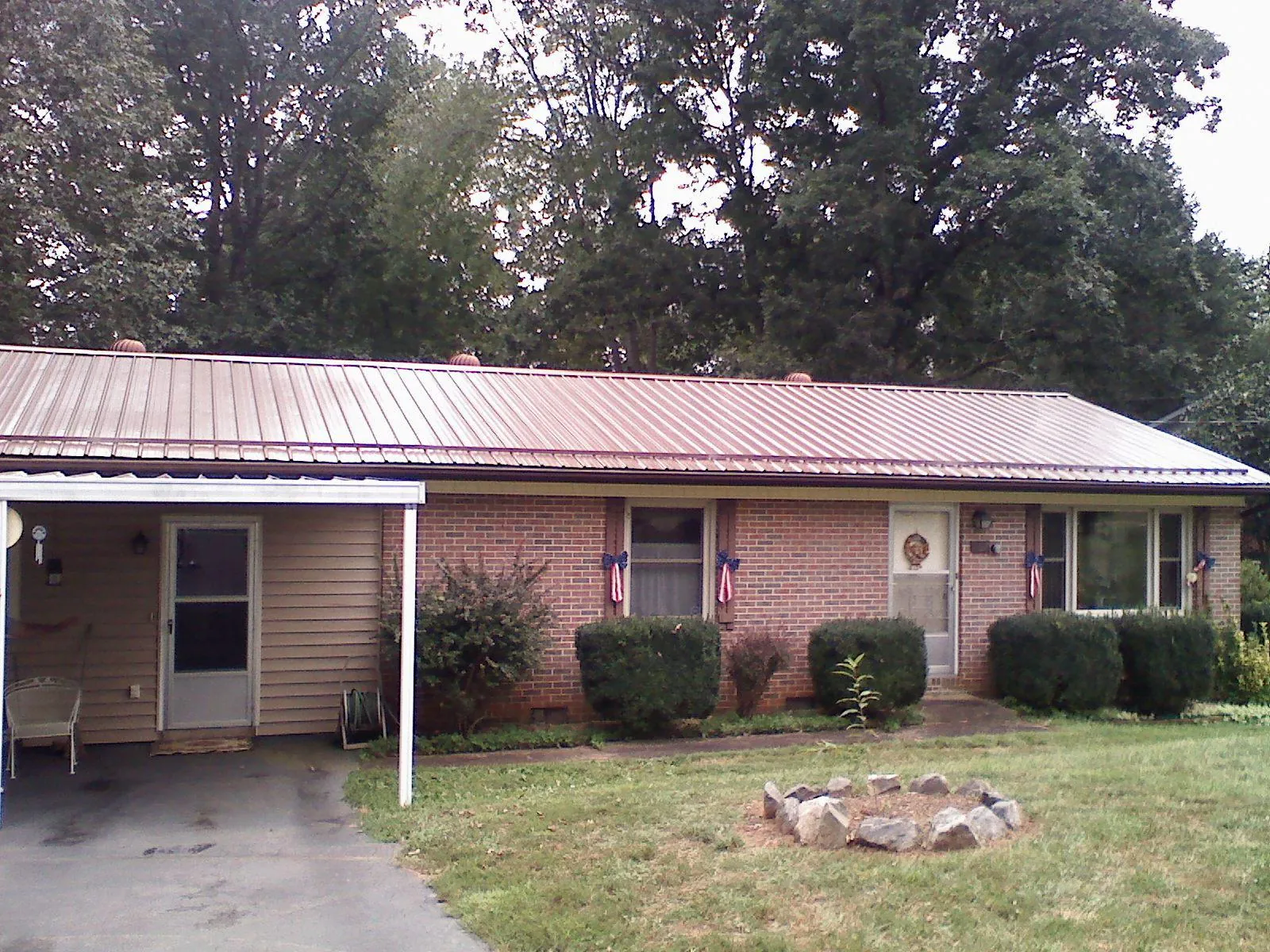 Bronze metal roof and carport on a brick ranch home — Roof Repair work by our crew in Karns City