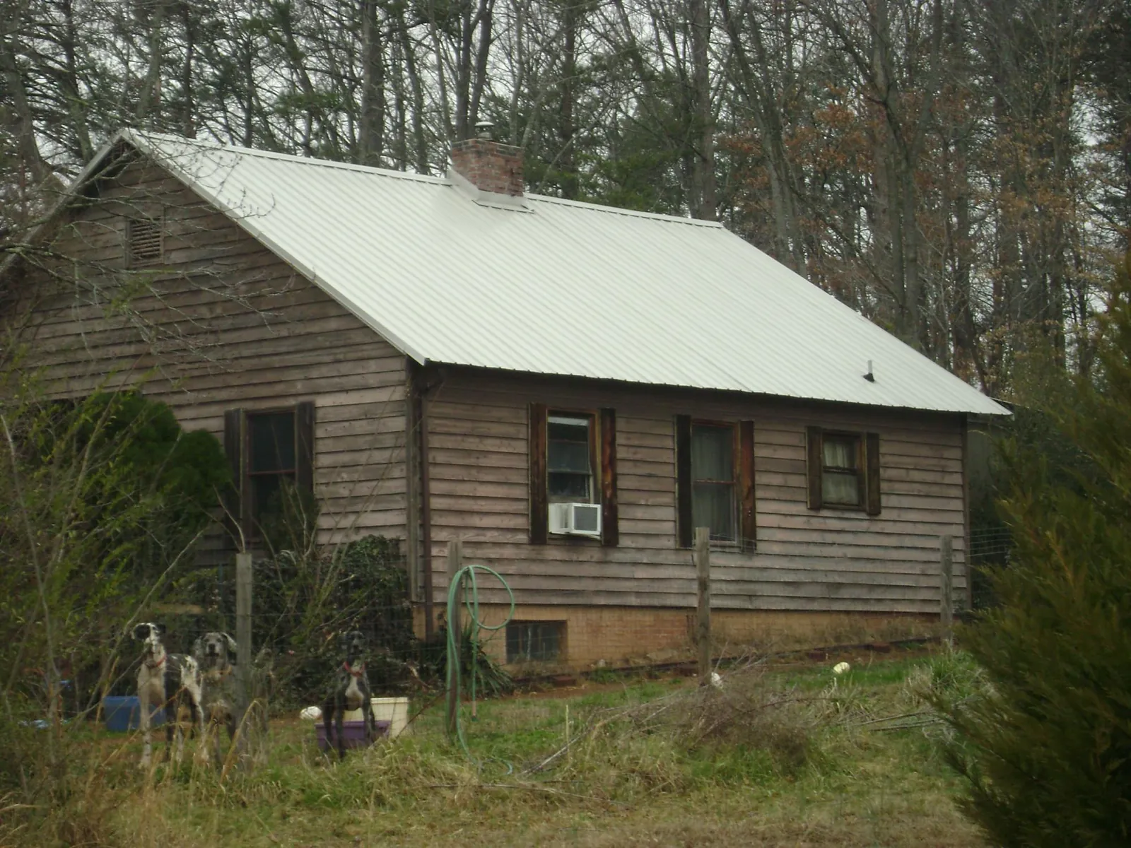 White metal roof on an old wood sided farmhouse, from a Metal Roof Installation job in Karns City